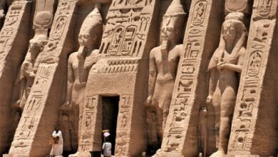 واجهة معبد صخرية تبرز ضخامة التماثيل ودقة النحت في العمارة المصرية القديمة.