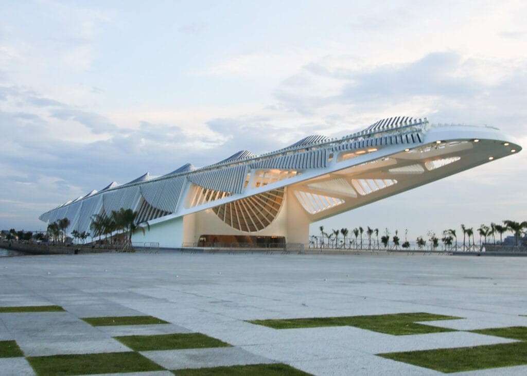 صورة لمتحف الغد (Museum of Tomorrow) من تصميم سانتياغو كالاترافا، يبرز هيكله المستقبلي الأبيض وأجنحته المتحركة المزودة بالألواح الشمسية، كأيقونة عالمية تجمع بين جمالية التصميم وتطبيقات الاستدامة والطاقة المتجددة.