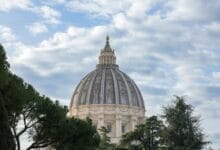 لقطة خارجية تُبرز القبة المهيمنة لكاتدرائية القديس بطرس في الفاتيكان، وتوضح تطور الأنظمة الإنشائية من البازيليك الطولية الكلاسيكية إلى المخططات المركزية المعقدة في عصر النهضة.