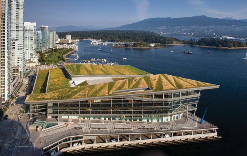 مشهد علوي لمركز مؤتمرات فانكوفر (Vancouver Convention Centre) المستدام، يبرز السطح الأخضر الحي الهائل الذي يغطي المبنى والمطل على الواجهة البحرية، كنموذج رائد لدمج الطبيعة في بنية المرافق العامة الكبرى.