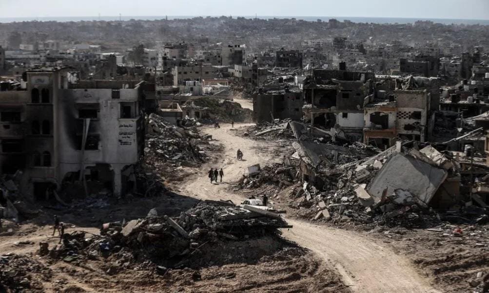 مشهد بانورامي لشارع مدمر في غزة، حيث تحول النسيج الحضري إلى تلال من ركام وأنقاض الرمادية التي تغلق الأفق العمراني.،