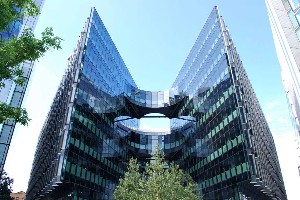 واجهة مبنى PWC (7 More London) في لندن، الذي يجسد معايير الاستدامة العالمية من خلال تصميمه المتعرج لتقليل استهلاك الطاقة، واستخدامه المبتكر للوقود الحيوي والأنظمة الذكية للتحكم في الإضاءة والحرارة.