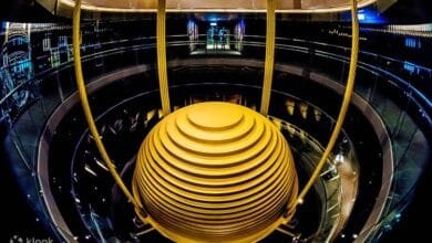 لقطة لبرج "Taipei 101" ومخمد الكتلة الترددي الذهبي، تجسد النظام الإنشائي الذكي بمحاكاة المفاصل الحيوية المرنة لامتصاص وتبديد طاقة الزلازل.