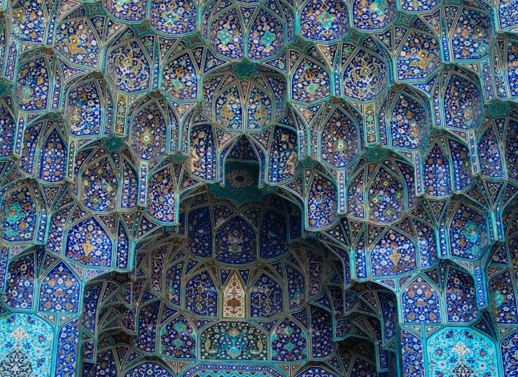 تفاصيل هندسية معقدة لمصفوفات المقرنصات الإسلامية الملونة التي طورت حلول نقل أحمال القباب جمالياً.