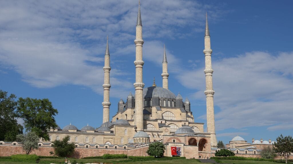 منظر خارجي لجامع السليمية في أدرنة من تصميم المعمار سنان، يظهر فيه التوزيع الهندسي المتقن للقبة المركزية الكبرى وأكتاف التحميل والمآذن الأربع الشاهقة، مما يعكس الفلسفة الإنشائية القائمة على توزيع الأحمال والتوازن بين الكتلة والمرونة لمقاومة القوى الزلزلية الأفقية.