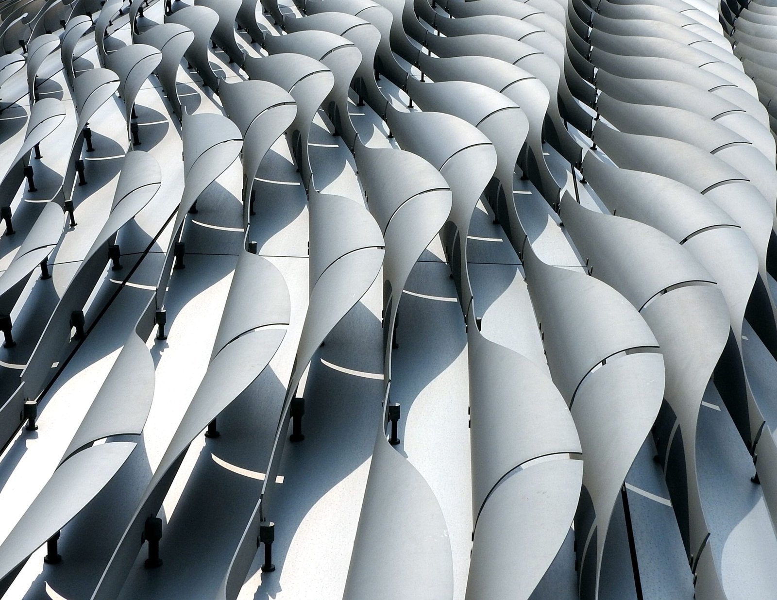 التصميم البارامتري (Parametric Design): ربط العناصر المعمارية بمعادلات رياضية يتيح تشكيل واجهات ديناميكية معقدة تتعدل تلقائياً للتكيف مع زوايا الشمس والظروف البيئية.